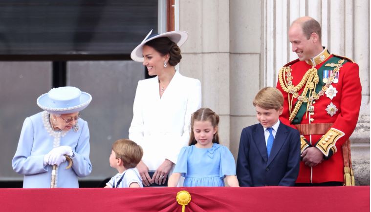 Prince William, Princess Kate, and their three kids alongside the late Queen Elizabeth II.